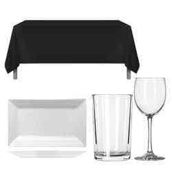 One black table cloth covering a long table, an empty wine glass, an empty water glass and a rectangular white plate all pictured on a white background.