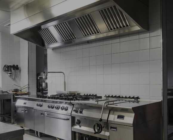 Commercial range, tilt steam table and hood in a commercial kitchen.