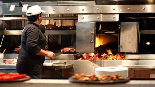 Argentinian chef cooking meat in the restaurant