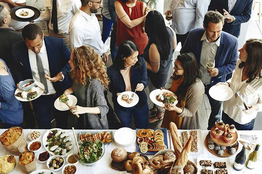 Party guests standing near a catered buffet