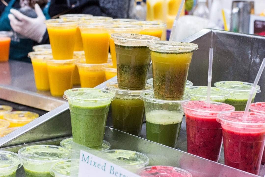 Fresh smoothies and juices in plastic cups at juice bar counter