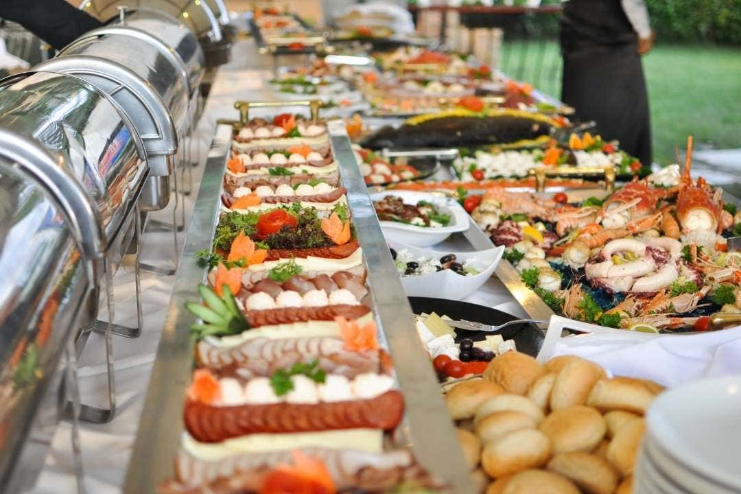 Catering setup – Buffet catering table with assorted dishes and stainless steel chafing dishes.