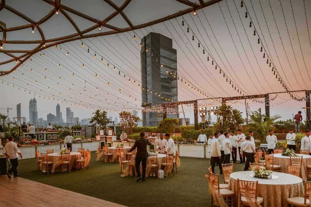 Outdoor rooftop banquet setup with round tables and chairs