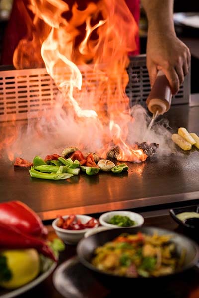 Chef doing flambe while preparing teppanyaki