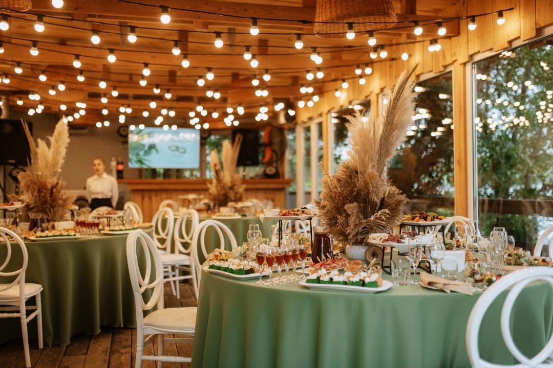 Decorated banquet hall with round tables set for a catered reception or event.