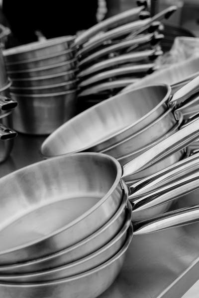 Stainless steel skillets and sauce pans stacked up.
