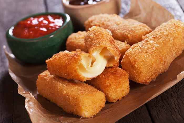 Breaded mozzarella cheese sticks with ketchup and bbq sauce