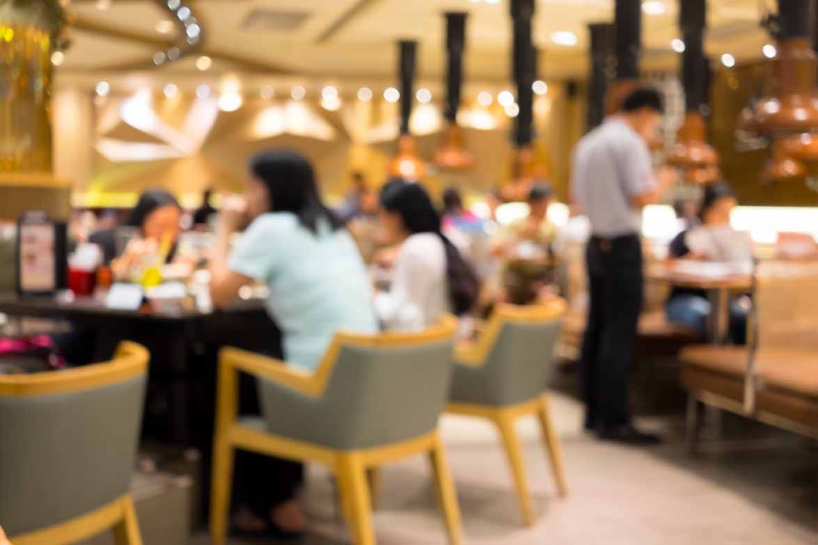 Out of focus photograph of people eating in a restaurant.