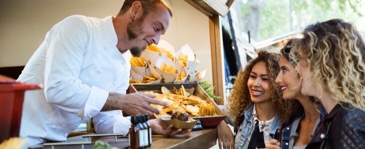Food truck cook giving food to customers