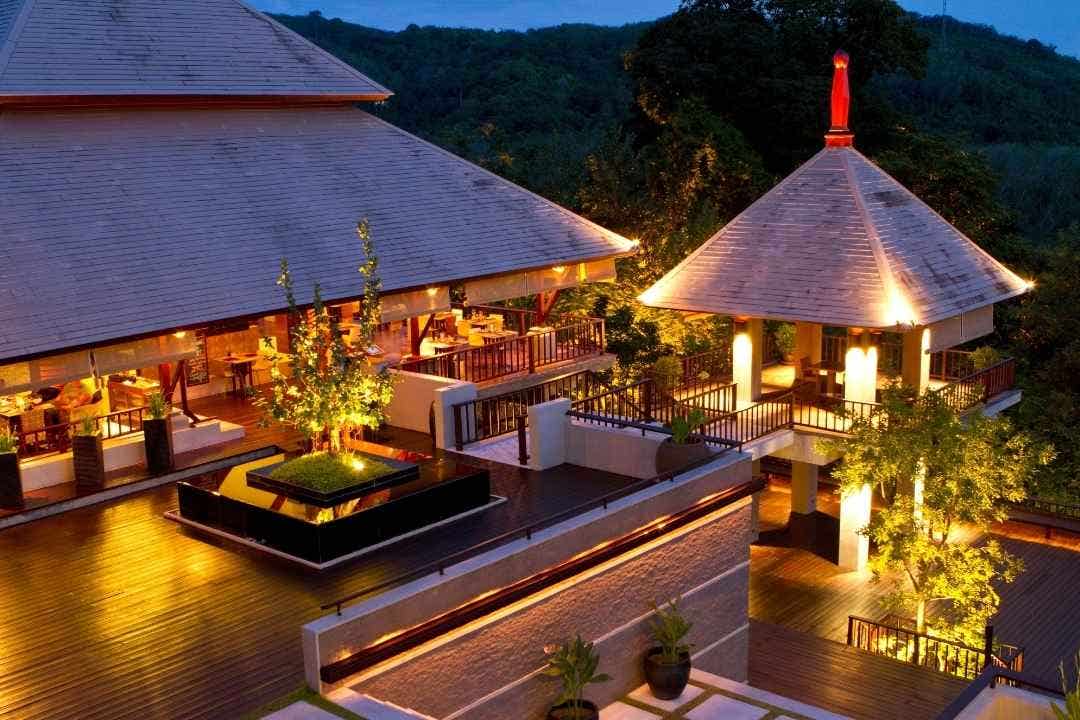 Luxury resort with open-air dining and soft lighting at twilight in a tropical setting