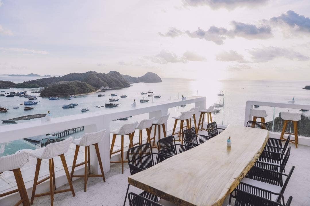 Rooftop restaurant patio with ocean views, modern seating, and island scenery