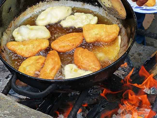 Traditional Ecuadorian sweet food - Cheese Empanadas cooked on open fire in big pot with oil