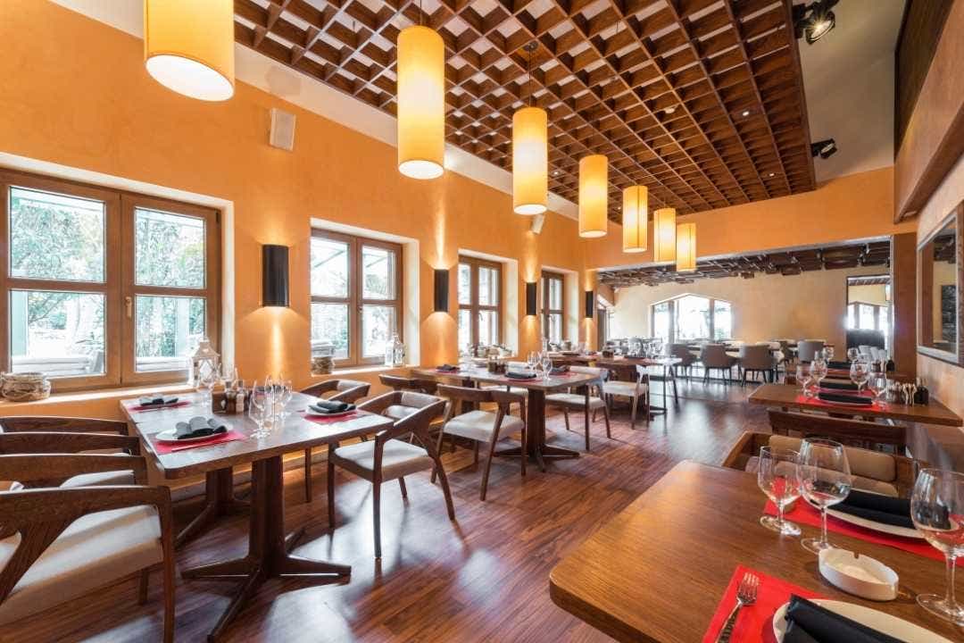 Elegant hotel restaurant with wooden decor and neatly set dining tables