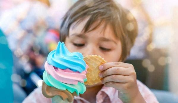 Kid eating multi-colored ice cream on a cone