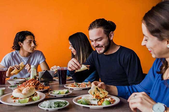 Mexican people eating Tacos al Pastor in a Taqueria in Mexico
