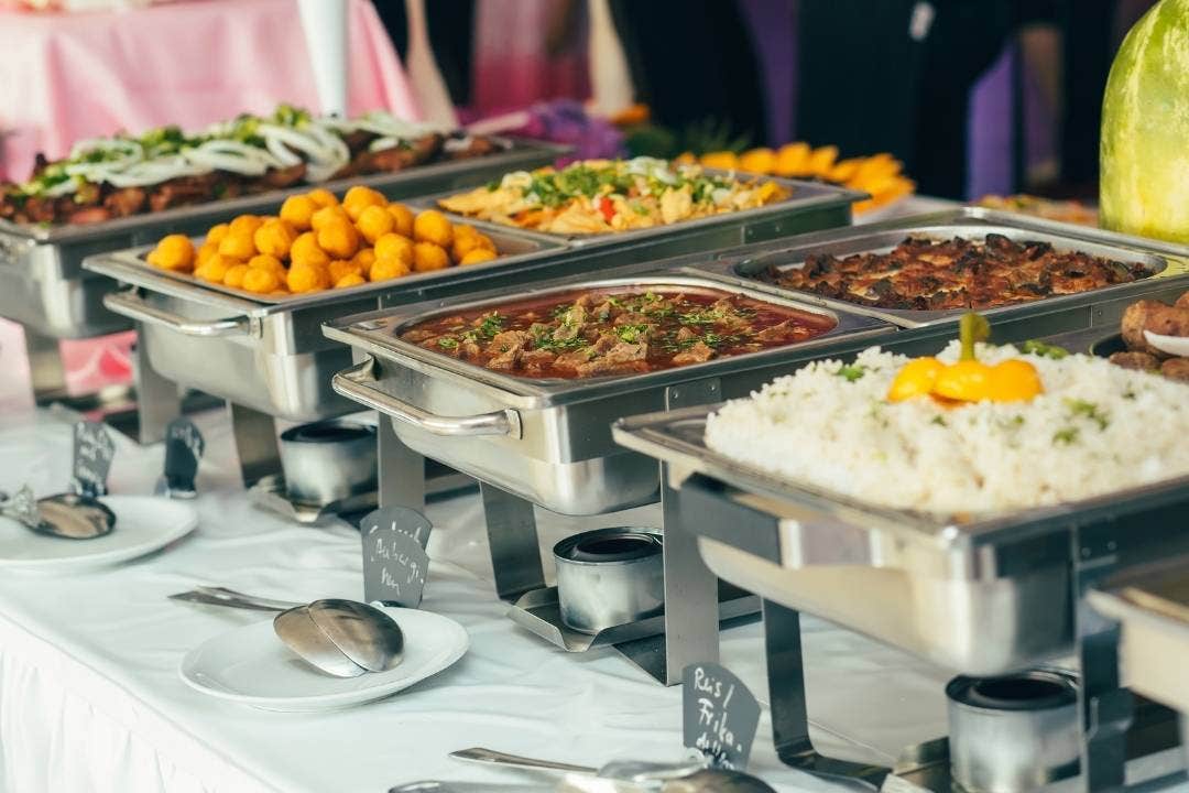 Hot food buffet setup with stainless chafing dishes at a catered event