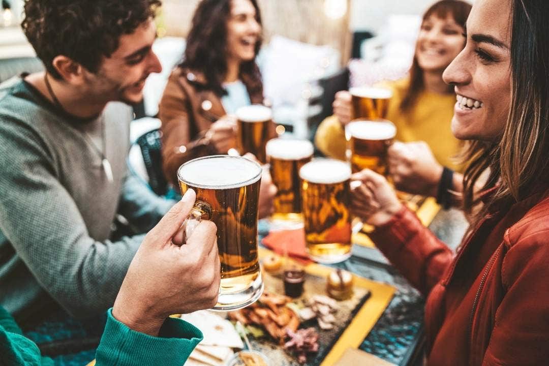 Friends enjoying beer and food at outdoor bar
