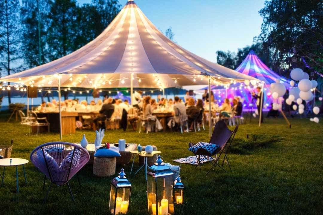 Outdoor event tent with cozy patio lounge furniture and string lights