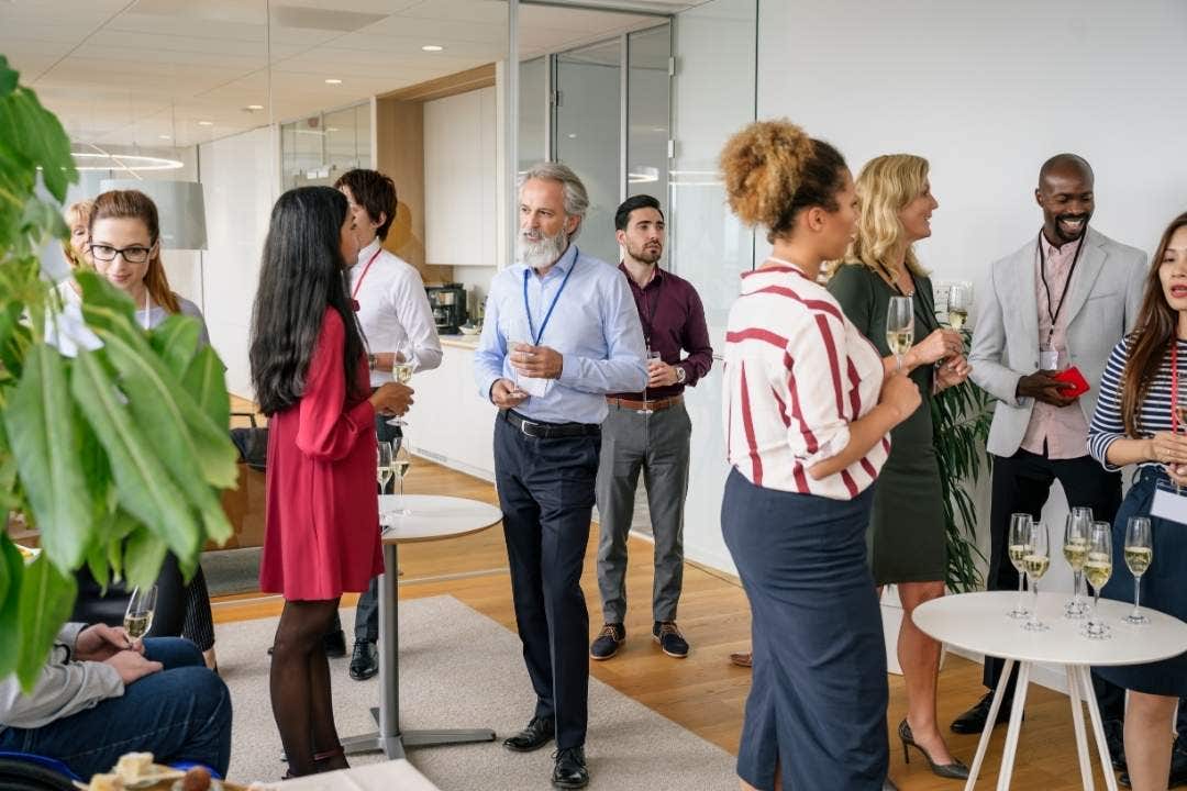 Group of professionals socializing at a modern office networking event
