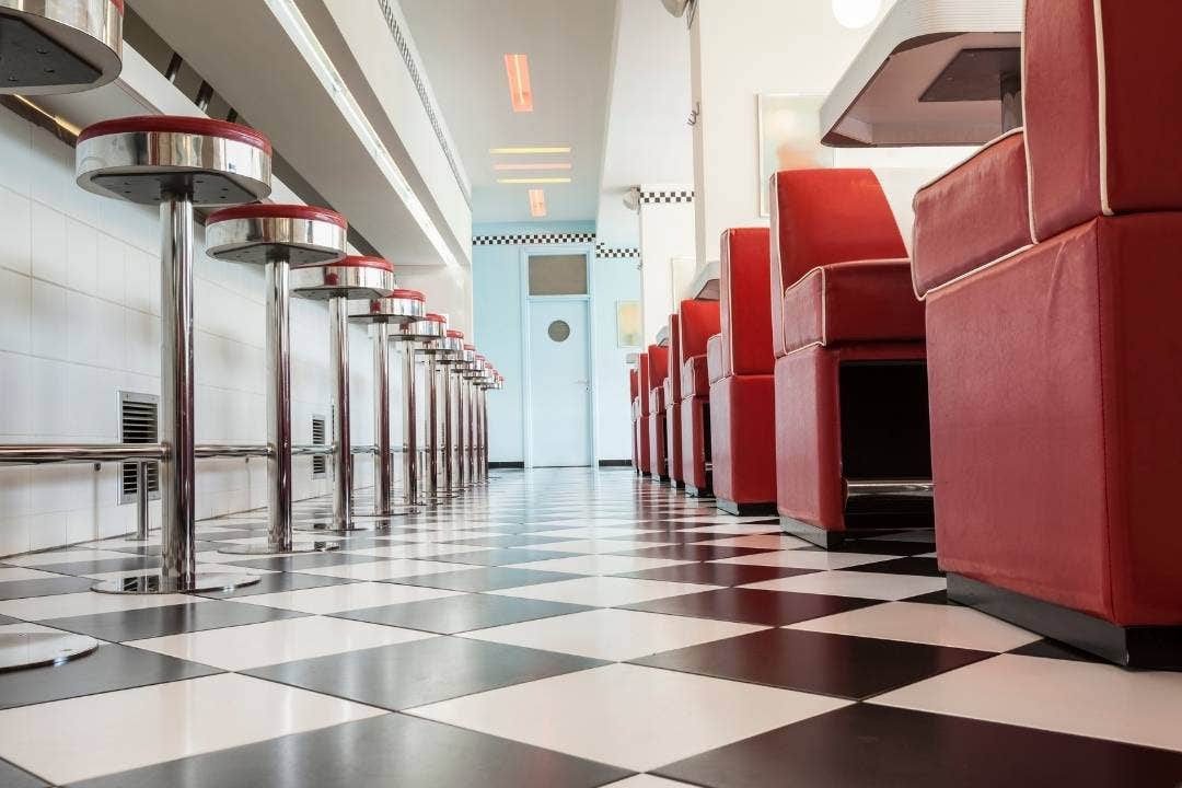 Classic American diner with retro red booths and checkered floor tiles.