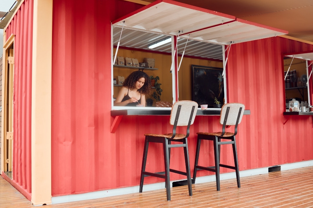 Pop-up restaurant with bright red container and casual dining window.