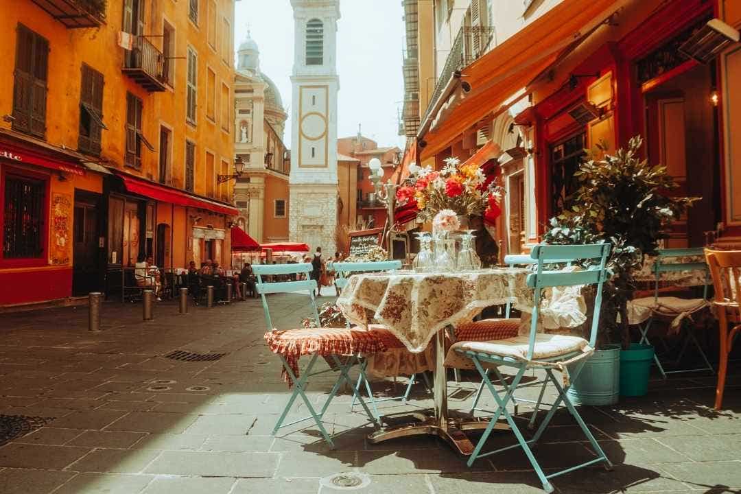 Charming European street café with colorful buildings and tower in background