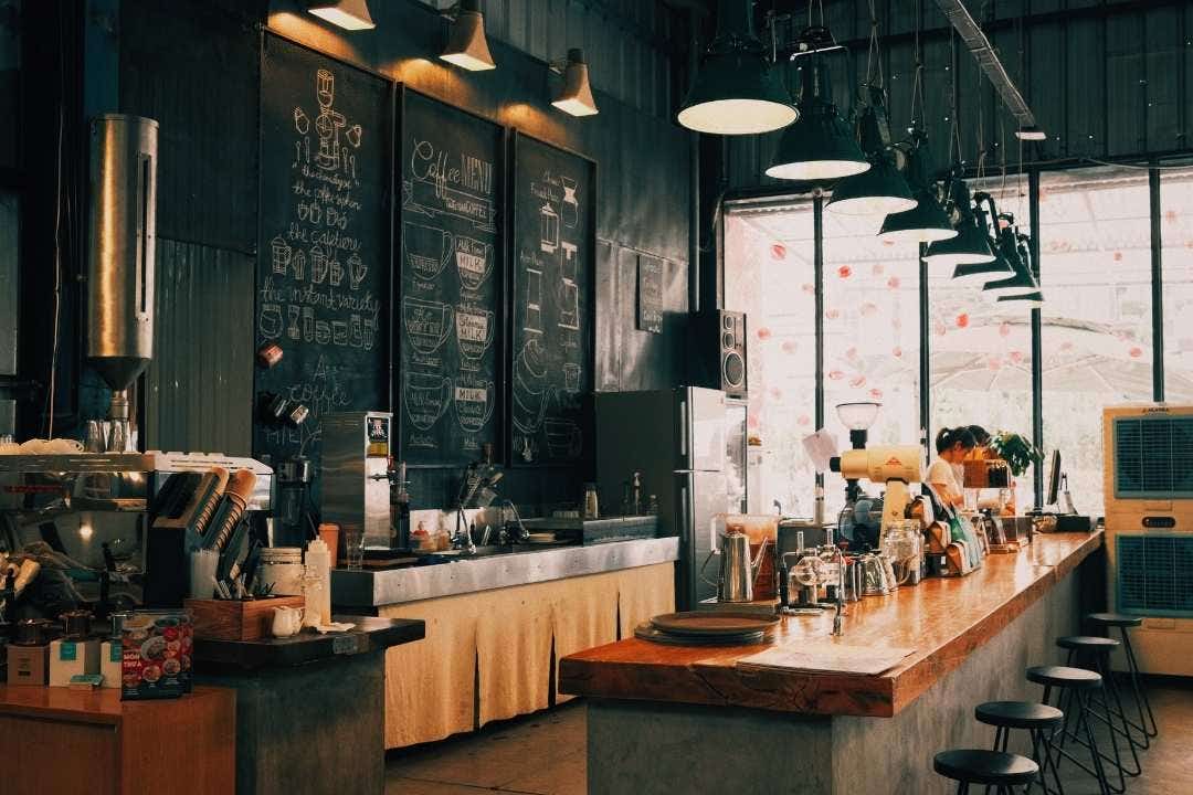 Cozy coffee shop interior with espresso bar, chalkboard menus, and wooden counters