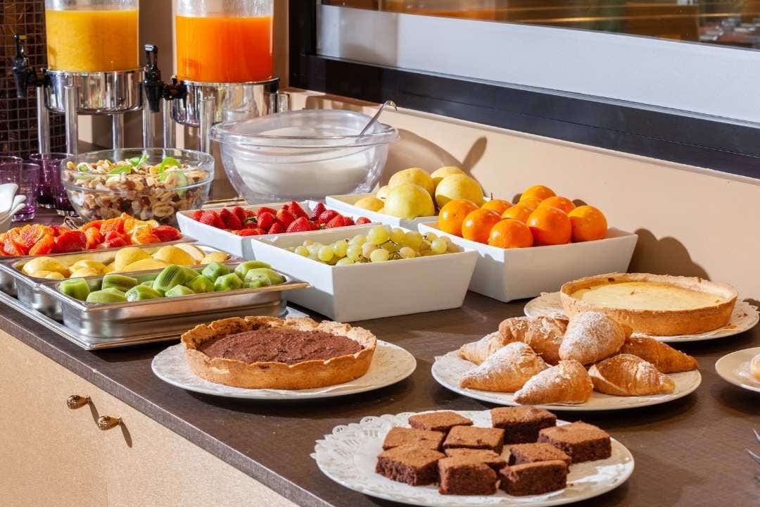 Hotel breakfast buffet with fruit, pastries, juice, and assorted morning treats