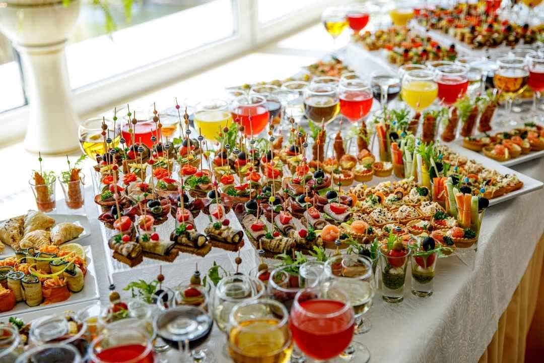 Colorful catering buffet with assorted appetizers and drinks.